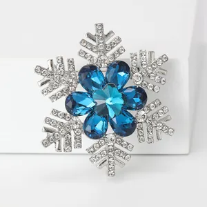 Macro detail of snowflake brooch with blue crystals and silver rhinstone petals