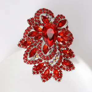 Detailed close-up of a large red crystal brooch with pear-shaped stones and silver setting