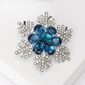 Macro shot of silver snowflake brooch with deep blue crystals and shimmering rhinestones