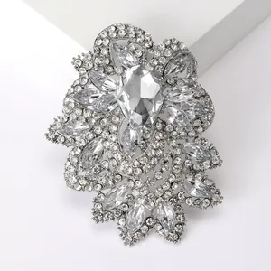 Macro shot of silver vintage brooch with pear-shaped crystal and flower petals