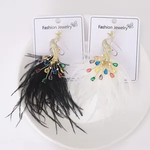 Detailed peacock earring with colorful crystals and soft feather drops on a display card