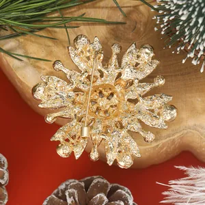 Detailed macro view of the gold plating and safety pin buckle on the snowflake brooch back