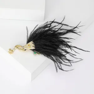 Vintage gold peacock brooch with green gemstone eye and black feather detail