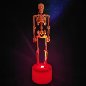 Makroaufnahme von glühendem rotem LED-Sockel und orangefarbenem Skelett für Halloween