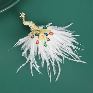 Detail of vintage peacock brooch with colorful crystals and soft white feathers