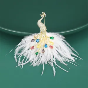 Detailed shot of gold peacock brooch with colorful crystals and white feather plumes
