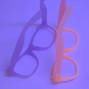 Glow-in-the-dark purple and pink neon glasses frames showing UV light fluorescence effect