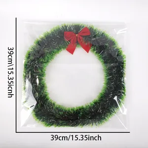 Dettaglio di ghirlanda natalizia verde da 38cm con fiocco rosso in confezione
