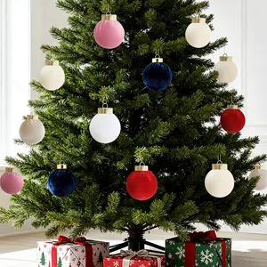 Velvet Christmas ornaments in assorted colors on a green tree with gift boxes