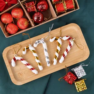Detail of colorful striped Christmas candy cane ornaments with metallic finish and cords