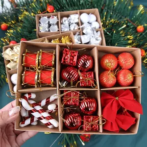 Macro shot of assorted red Christmas ornaments and velvet bow in a kraft paper gift box