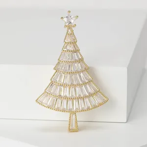 Makroansicht einer glitzernden Weihnachtsbaum-Brosche mit Zirkonia auf Goldbasis