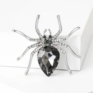 Macro shot of a vintage silver spider brooch with a grey teardrop gem and rhinestones