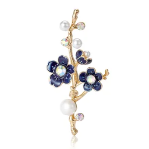 Elegant plum blossom branch brooch with blue enamel flowers and white pearls on white background