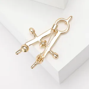 Polished gold alloy compass brooch shown from a 45-degree angle on minimalist white background