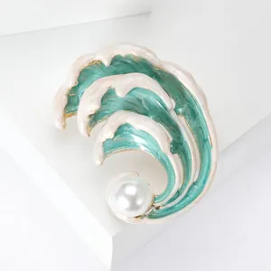 Detail of artistic enamel sea wave brooch with pearl and elegant gold-plated edges