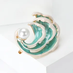 Macro shot of sea wave enamel brooch with a large white pearl and gold accents