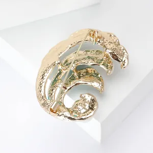 Detailed back view of gold wave brooch showing secure pin fastener and hammer texture