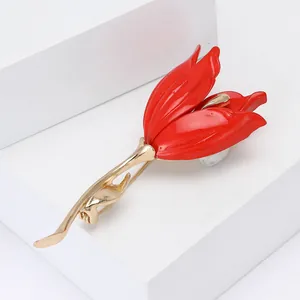Detail of elegant red tulip brooch with gold metal leaf and white pearl accent