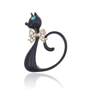 Cartoon-Brosche als schwarze Katze mit grünen Edelsteinaugen und glitzernder Schleife