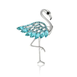 Elegante broche de flamenco con cristales azules y acabado plateado sobre fondo blanco