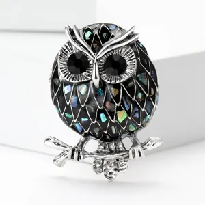 Fashionable owl brooch with iridescent enamel inlay and black crystal eyes on silver branch