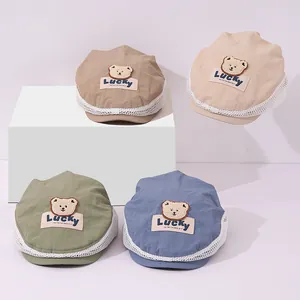 Detail of children's mesh beret featuring a cute plush bear patch and breathable fabric