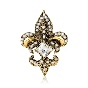 Vintage golden fleur-de-lis brooch with white pearls and a square crystal centerpiece