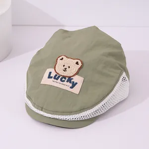 Detail of toddler mesh cap with breathable white side panels and cute bear patch