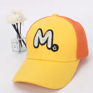 Detail of breathable mesh truck cap with yellow and orange panels and large M patch