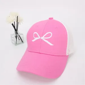 Close-up of pink baseball cap featuring white bow embroidery and breathable mesh back