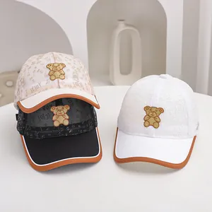 Close-up of breathable mesh baseball caps with gold bear embroidery and piping detail