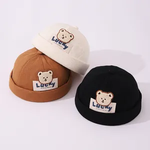Tres gorros tipo docker para niños con parches de oso de peluche en blanco, marrón y negro