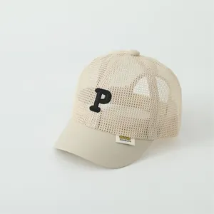 Detail of beige mesh baseball cap for kids with black P embroidery and breathable fabric