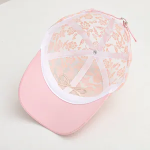 Detail of pink floral mesh cap featuring breathable net and inner bow ornament