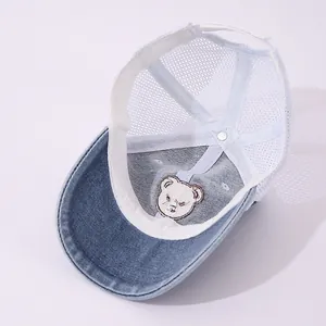 Detail view of denim baby baseball cap featuring breathable mesh and bear patch