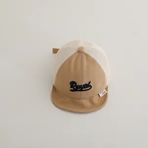 Detail of baby baseball cap featuring mesh panels and Royal embroidery in khaki white