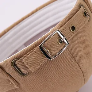 Detalle de hebilla metálica y tejido de sarga en un gorro vintage caqui para niños