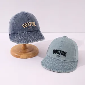 Dettaglio del ricamo BOSTON 1630 su visiere parasole in denim lavato per bambini