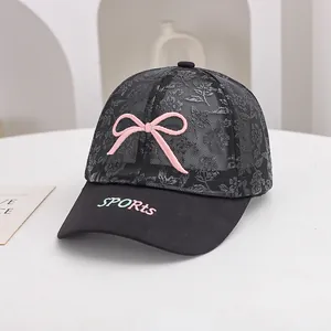 Detailed shot of breathable black lace mesh fabric and pink bow on summer mesh cap