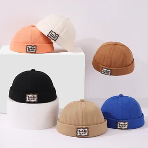 Detalle de seis colores de gorros docker de lona para niños con parches de oso bordados