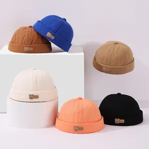 Detalle de gorros infantiles de varios colores con parche de cuero de oso y borde doblado