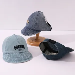 Dettaglio del ricamo Boston 1630 su visiera parasole per bambini in denim lavato