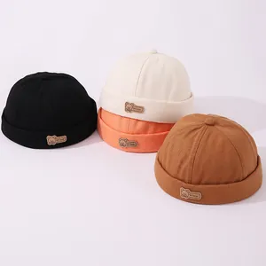 Detalle de cuatro gorros de algodón de colores con parches de oso para niños 2-6 años