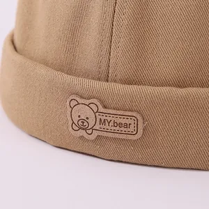 Primer plano del gorro de algodón caqui con la etiqueta MY.bear y costuras detalladas