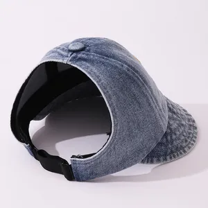 Dettaglio della visiera in denim lavato blu con cinturino regolabile e trama del tessuto