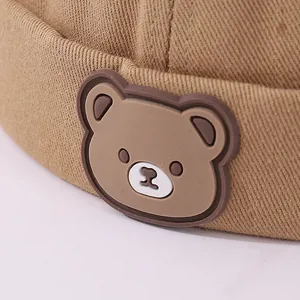 Detalle macro de parche de oso en gorro de algodón caqui de estilo chino infantil