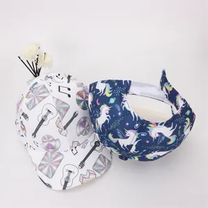 Dettaglio del cappellino bianco con musica e visiera blu scuro con unicorno per bambini