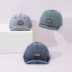Three shades of denim baby baseball caps with Smile patches and soft short brims
