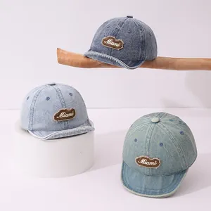 Detailed close-up of three vintage denim baby baseball caps with Miami embroidery patches